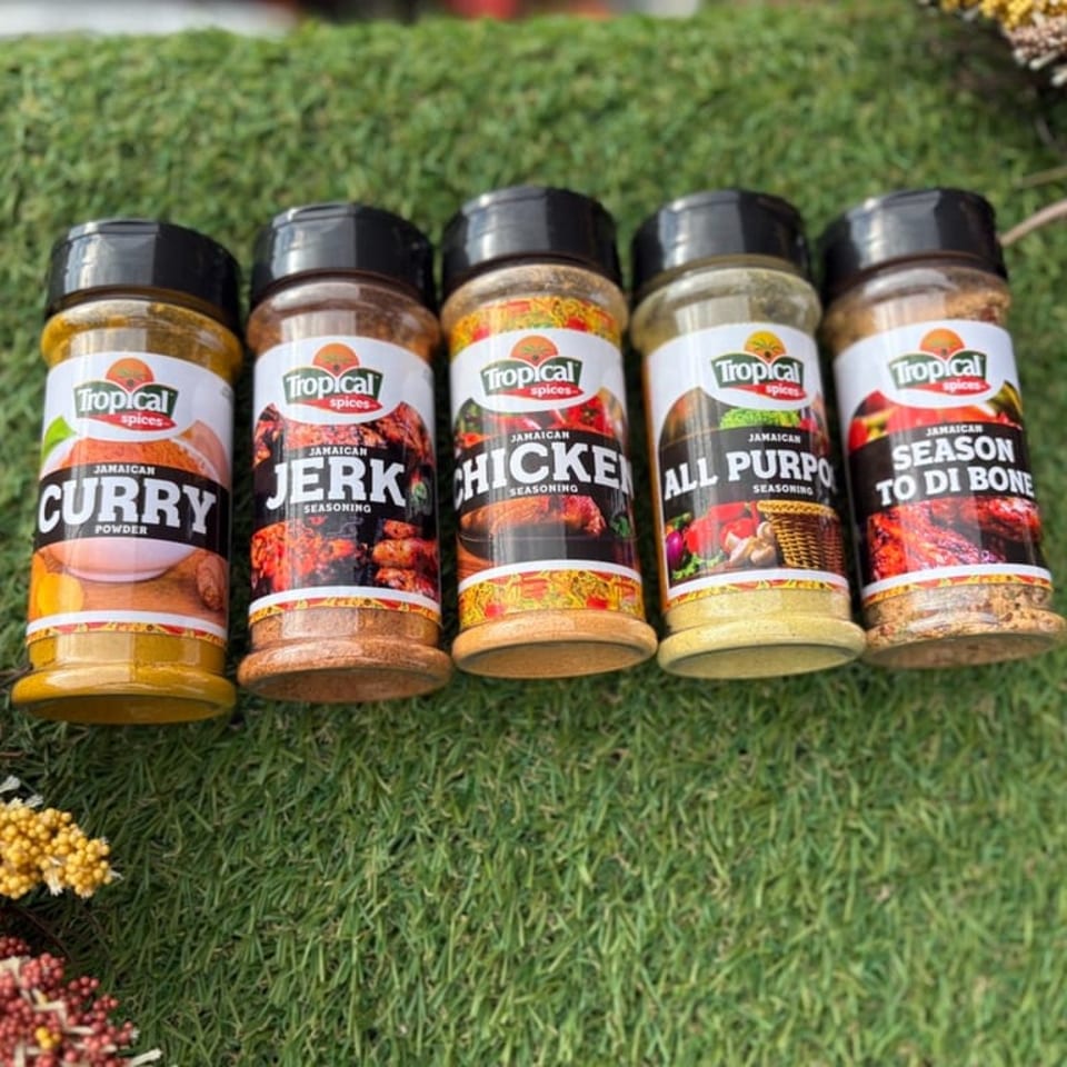 Five Tropical Spices seasoning bottles, including Curry, Jerk, Chicken, All Purpose, and Season To Di Bone.