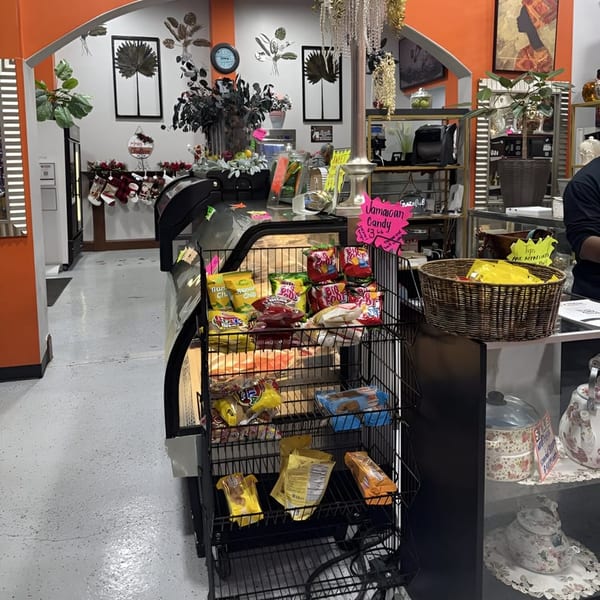 A store interior with snacks on display, a counter, and decorative elements like plants and wall art.