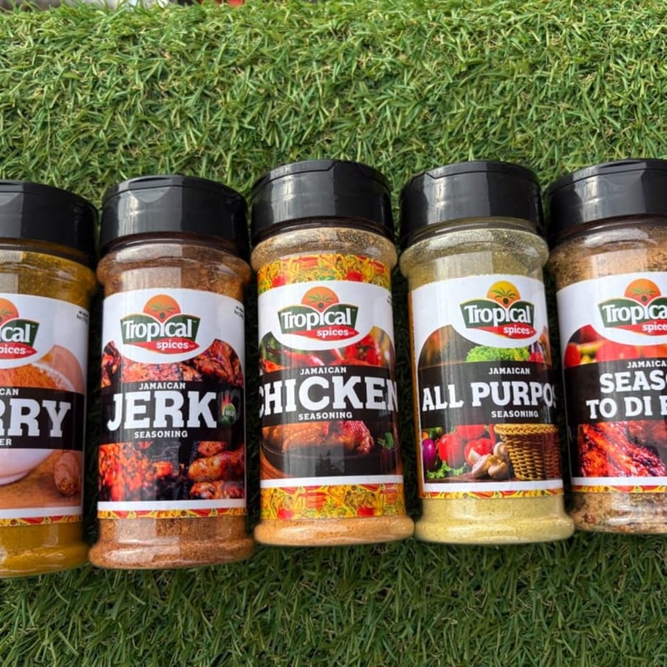 Five Tropical Spices Jamaican seasoning bottles, including Curry, Jerk, Chicken, All Purpose, and Season to Di.