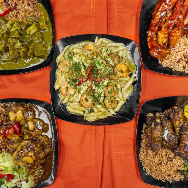 Five plates of diverse Caribbean dishes, including curry, pasta with shrimp, and oxtail, on an orange tablecloth.